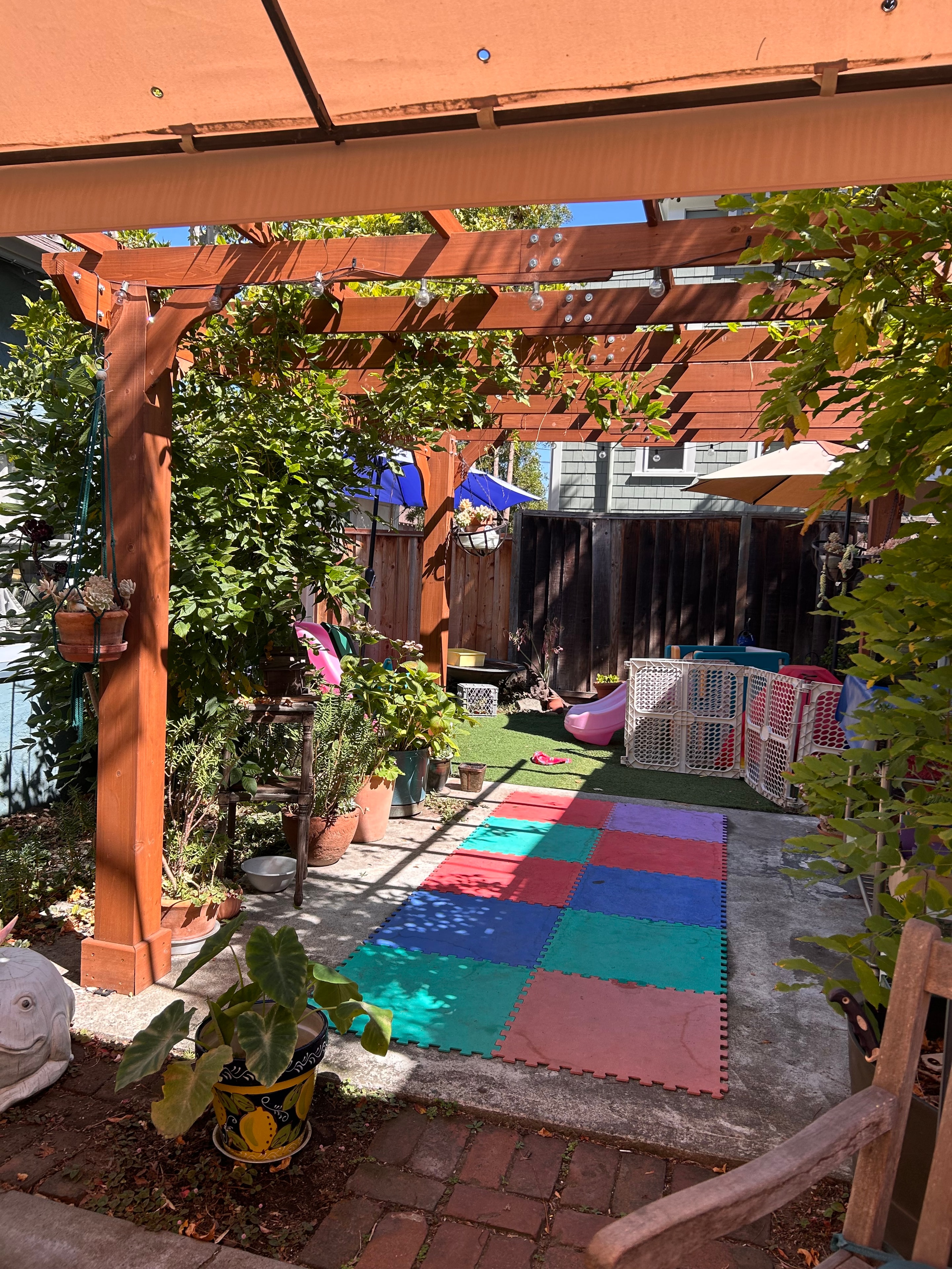 Backyard outdoor area with wooden pergola at Little Crumbles